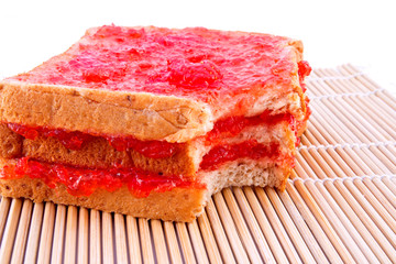 Whole wheat bread with strawberry jam on mat