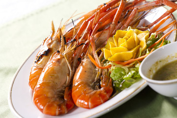 orange grilled prawn with sour sauce in a dish