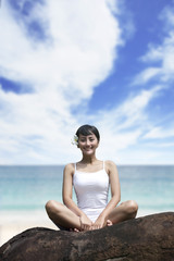 Fototapeta na wymiar Smiling woman sitting on a rock