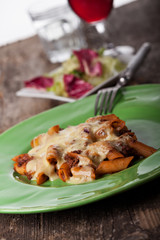 Rigatoni Bolognese auf einem grünen Teller