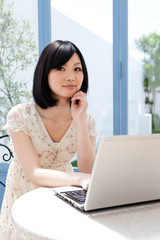 Beautiful young woman using a laptop computer. Portrait of asian