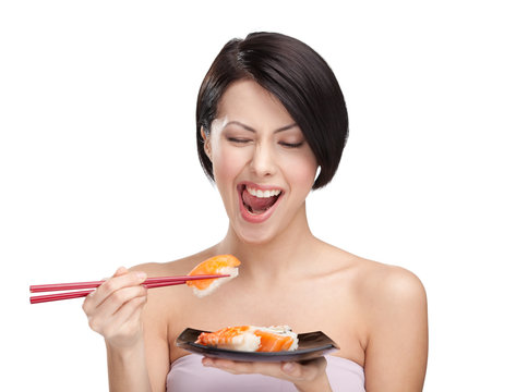 Young attractive woman eating sushi with a chopsticks