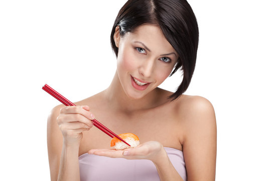 Attractive woman holding sushi with a chopsticks