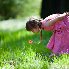 Little girl sniffing flower