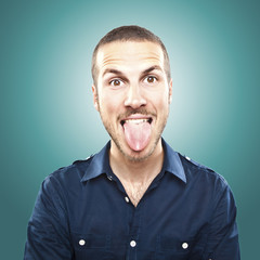Obraz premium portrait of a young beautiful man showing tongue, face expressio