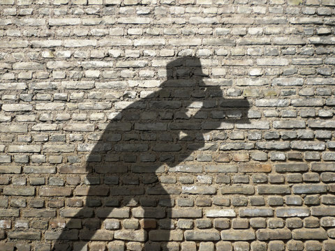 ombre de photographe sur mur de briques