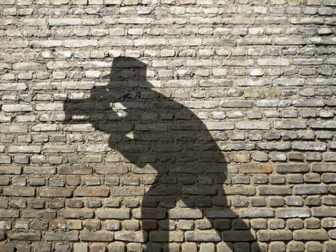 ombre de photographe sur mur en briques