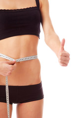 A woman measuring her waist with a tape measure
