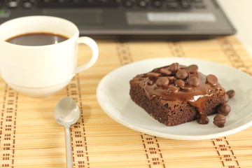 Fototapeta na wymiar chocolate cake and a coffeecup lab top