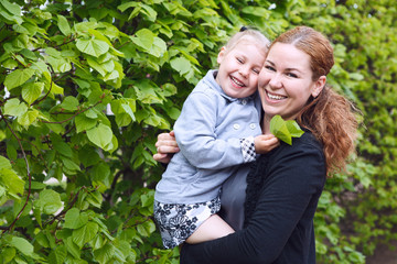 Happy mother and little daughter on woman`s hands. Copy space