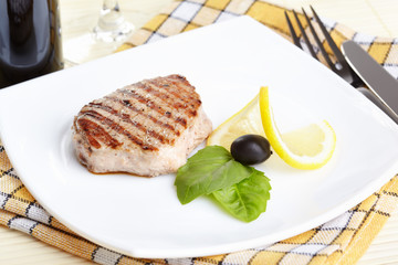 Grilled steak on white plate closeup