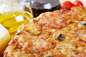 Italian cuisine. Pizza with salami, pickles and olives