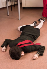 Business woman lying on the floor. Crime scene simulation