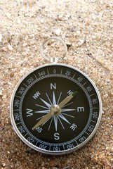 compass on the sea sand and place for text