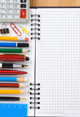 back to school concept and checked notebook on wood background
