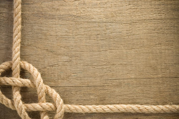 ship ropes with knot on wood background