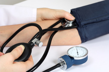 Doctor measuring patient blood pressure