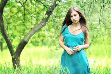 Naklejka na ściany i meble Young beautiful girl standing in the woods