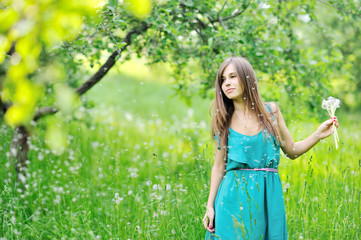 Naklejka na ściany i meble Girl with a dandelions outdoors