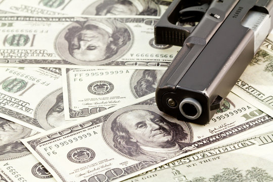 close up image of pistol and dollar