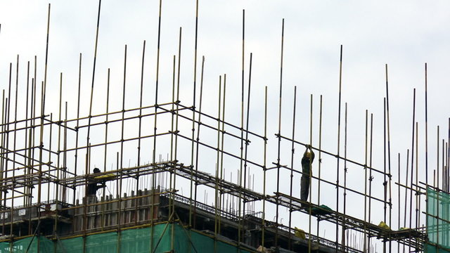 Time lapse of Construction workers atop building