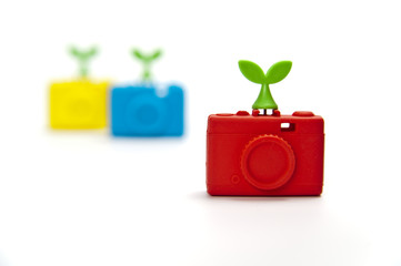 Zoom in red silicon compact camera with green leaf on top