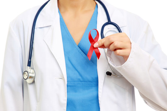 A female doctor holding a red ribbon as a symbol of AIDS