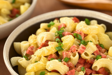 Pasta with sausage, grated cheese and scallion in bowl