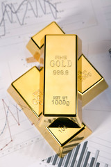Photo of gold bars on graphs and statistics, studio shots