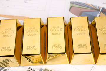 Photo of gold bars on graphs and statistics, studio shots