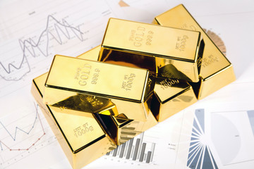 Photo of gold bars on graphs and statistics, studio shots