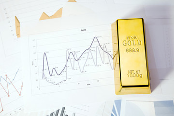 Photo of gold bars on graphs and statistics, studio shots
