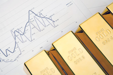 Photo of gold bars on graphs and statistics