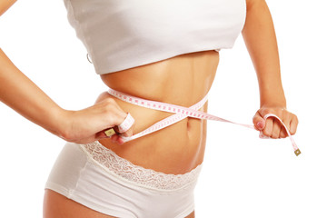 A slim girl measuring her waist, closeup