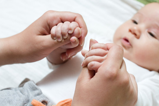 baby holding mother hand