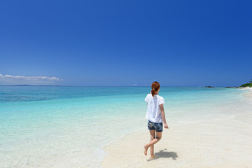Fototapeta na wymiar 水納島のビーチで寛ぐ女性
