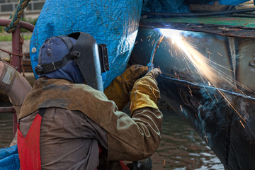 Welder in a protective mask when working.