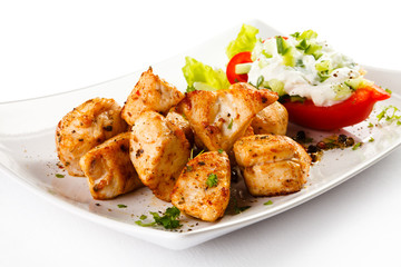 Grilled meat and vegetables on white background
