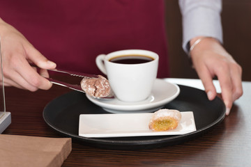 bedienung legt keks zum kaffee