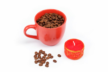 Coffee beans in the cup and a candle on a white background.