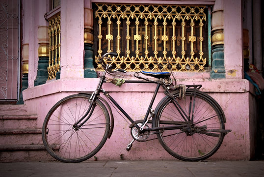 old bicycle leaning against vintage facade