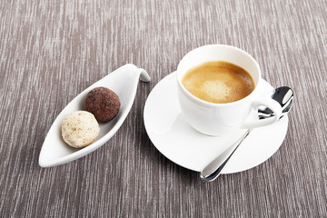Tasse Kaffee mit einer Auswahl an Pralinen aus Schokolade