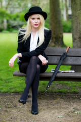 Beautiful young business woman sat on park bench