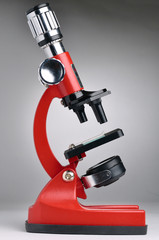 red microscope on gray background