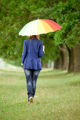 Young fashion girl with umbrella at spring outdoor.