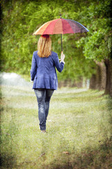 Young fashion girl with umbrella at spring outdoor.