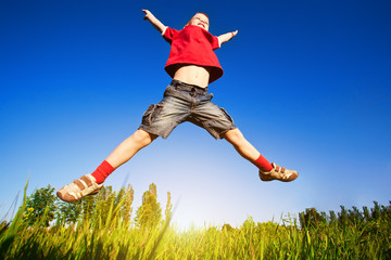 boy jumping against the blue sky