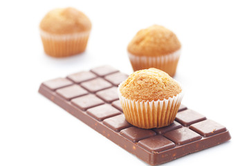 bar of dark chocolate and muffin isolated on white