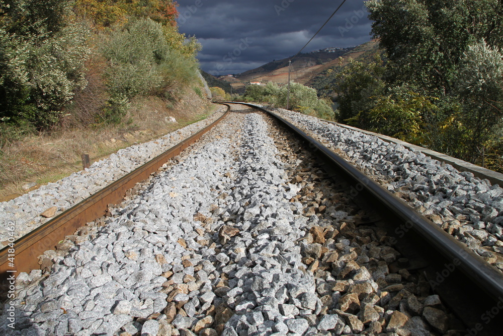 Wall mural railway in the mountains with heavy sky