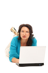 A woman lying on the floor with a laptop, isolated on white